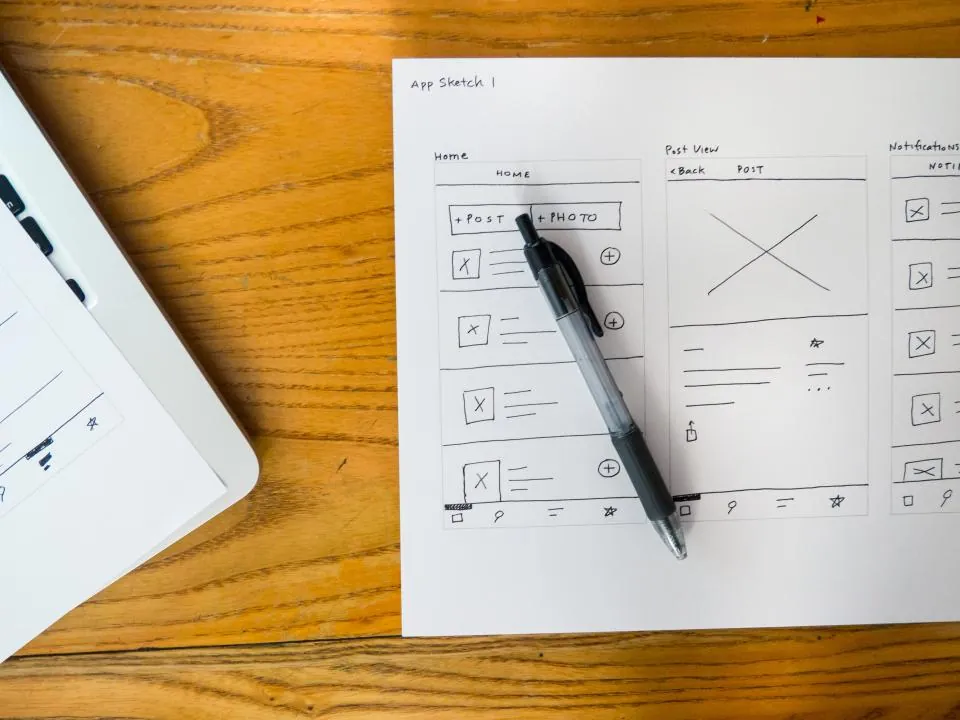 Hand-drawn mobile app wireframes on paper