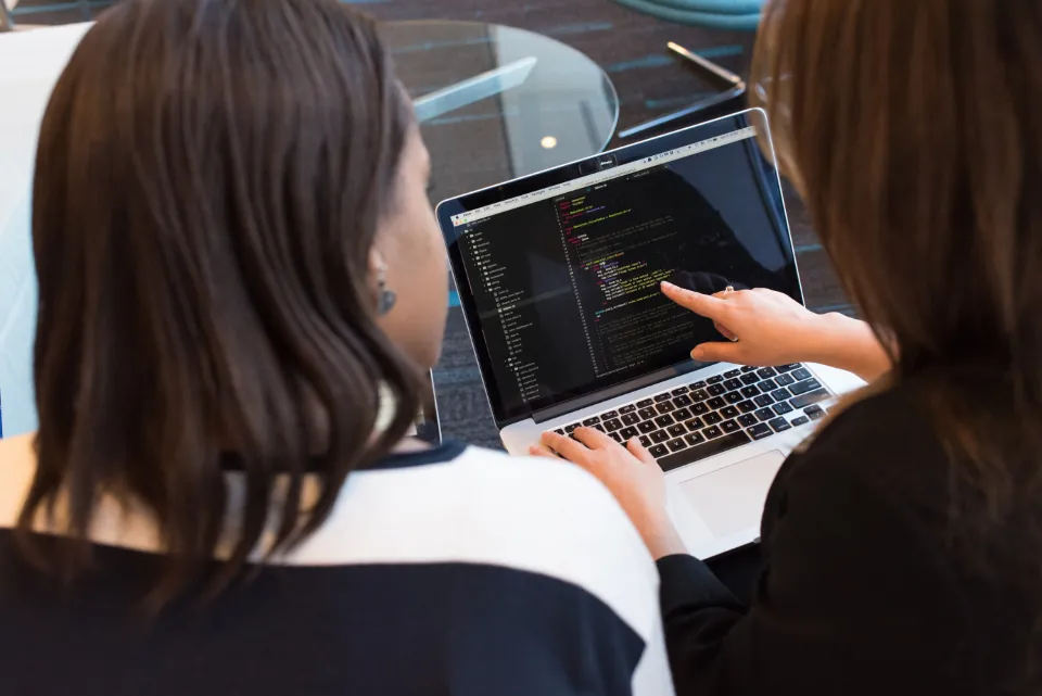 Mentor and intern reviewing code together on a laptop