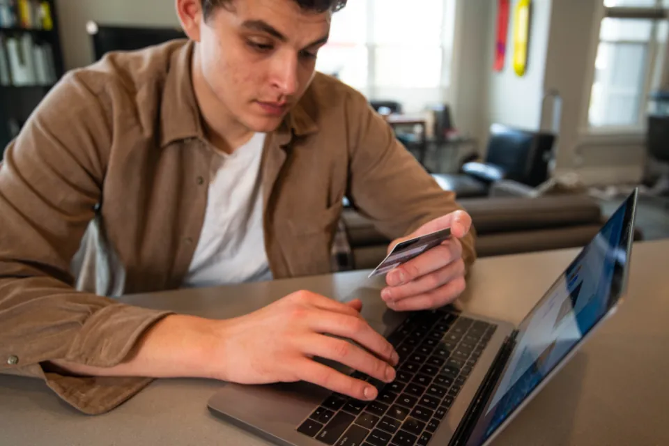 Customer paying online with a card on a laptop