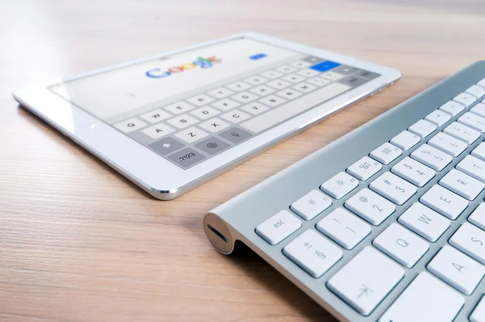 Tablet showing a search engine page beside a keyboard