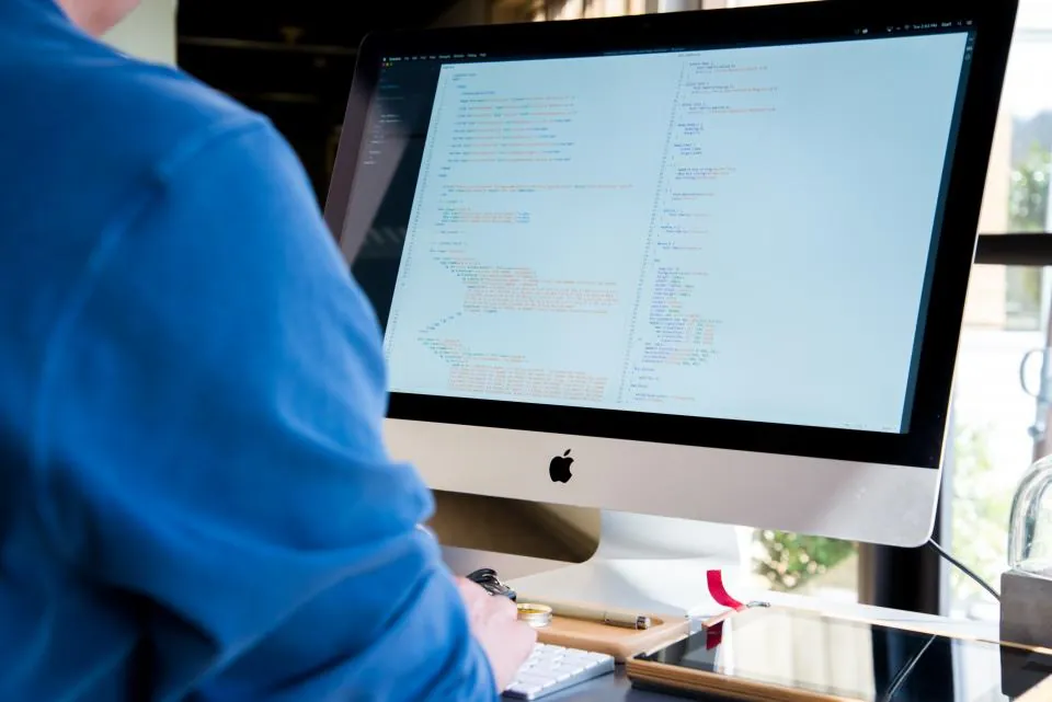 Developer writing website code on a desktop computer
